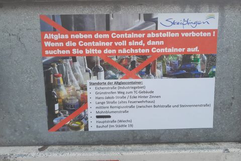 Hinweisschild auf einem Altglascontainer, dass es verboten ist, das Altglas neben dem Container abszustellen